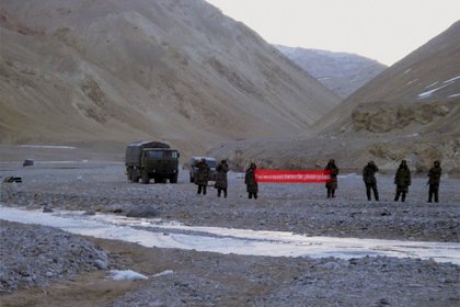 En esta foto de archivo pueden verse a tropas chinas en la región de Ladakh, reclamada también por India, con un cartel en inglés que dice "ha cruzado la frontera, por favor de la vuelta" (AP)