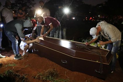 Un hombre reacciona junto el ataúd de su padre, que murió de la enfermedad coronavirus (COVID-19), antes de que lo entierren en el cementerio de Vila Formosa, el más grande de Brasil, en Sao Paulo. 19 de junio de 2020. REUTERS/Amanda Perobelli