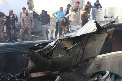 Rescatistas buscan los cuerpos entre los restos del avión estrellado en Karachi (EFE)