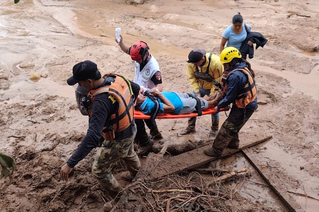 Personal de salud y equipos de rescate asisten a una persona afectada tras el desborde del Piraí. en El Torno / Foto: EFE.