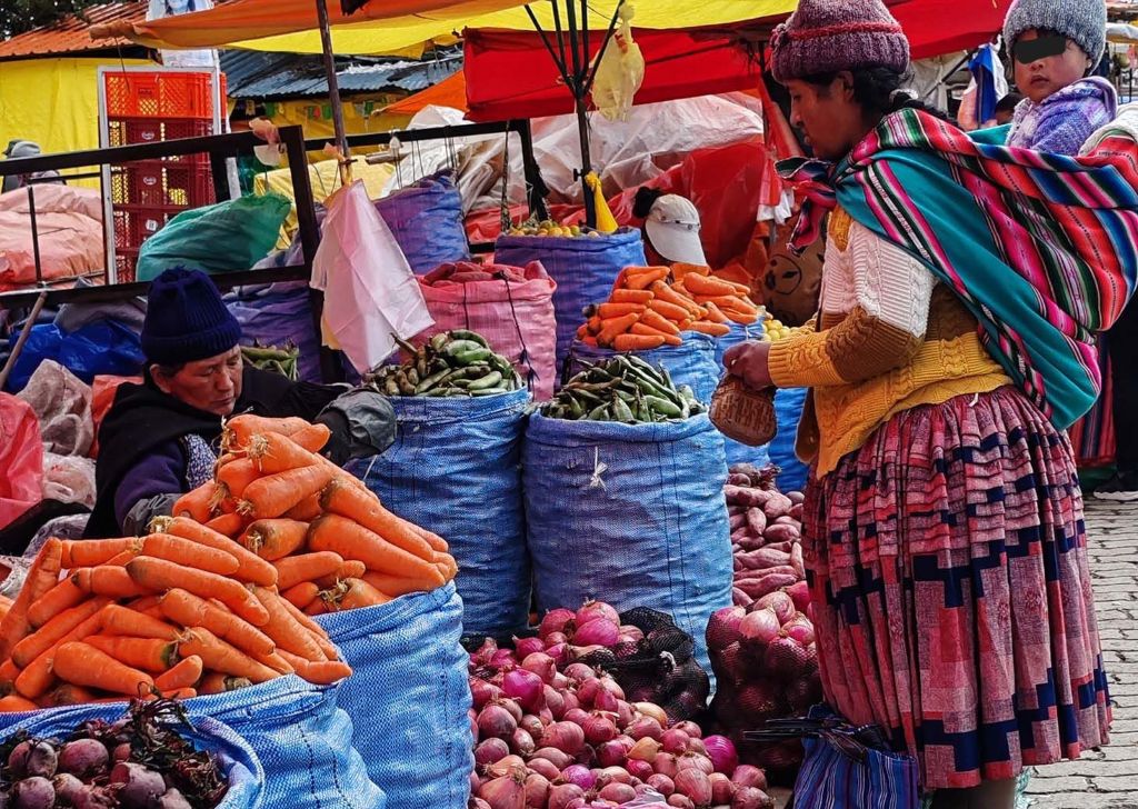 Una mujer compra verduras en un mercado de El Alto. / Foto: Prensa Alteña.