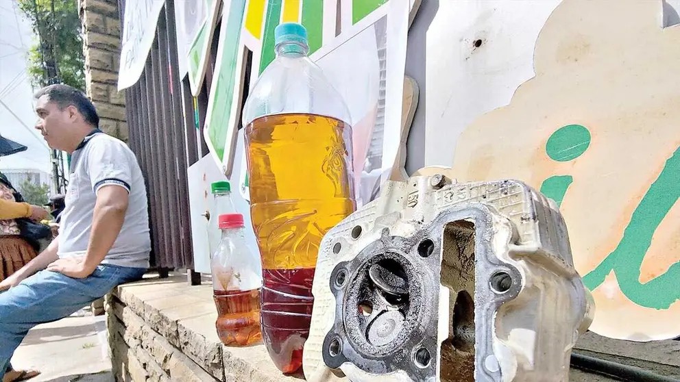 Dueños de vehículos, tras una protesta, muestran una pieza dañada y gasolina de “mala calidad”. / Foto Dico Solís - Opinión.