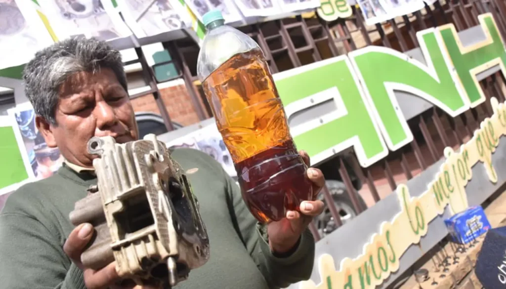 Una persona muestra la gasolina que supuestamente daño su vehículo. / Foto: APG