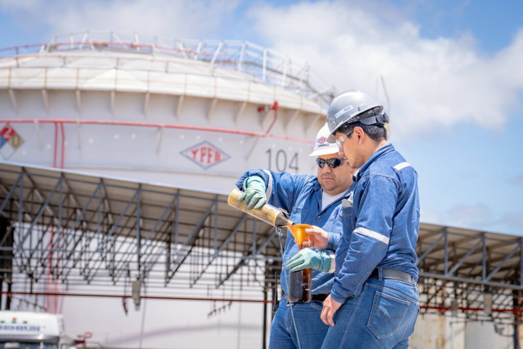 Dos funcionarios revisan la calidad de la gasolina en una planta de YPFB. / Foto: YPFB.