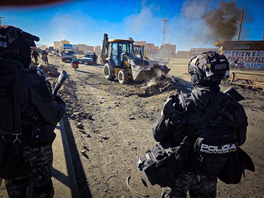 Dos policías vigilan el despeje de una ruta en El Alto. / Foto: Policía Boliviana.