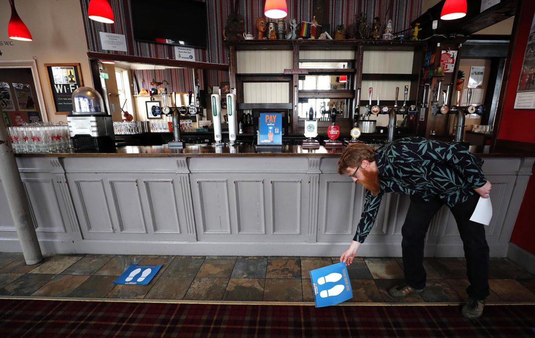 Un hombre acondiciona un pub para la reapertura (AP Photo/Frank Augstein)