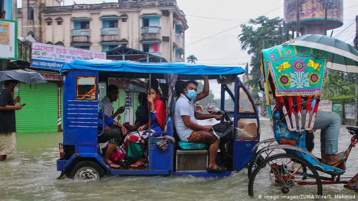 Foto de personas en calle inundada en Bangladesh