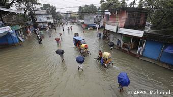 Foto de personas en calle inundada de Bangladesh 