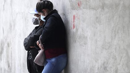 Dos mujeres con barbijo en la puerta del hospital Pablo Arturo Suárez de Quito (AP Photo/Dolores Ochoa)