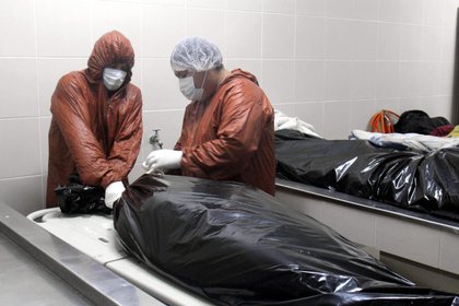 Trabajadores envuelven un cuerpo en la morgue del Hospital Pampa de la Isla el pasado domingo 12 de julio, en Santa Cruz (Bolivia). EFE 