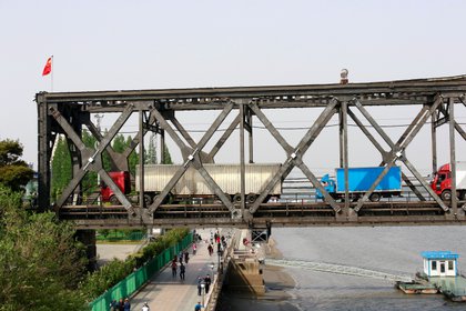 Camiones esperan para ser inspeccionados en la parte china del Puente de la Amistad que conecta Sinuiju, en Corea del Norte, con Dandong, en China (REUTERS/Jacky Chen/archivo)
