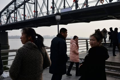 Turistas cerca de otro puente sobre el río Yalu que separa a los dos países (REUTERS/Tingshu Wang)