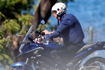 El presidente de Brasil Jair Bolsonaro en su moto Honda en las afueras del Palacio de Alvorada (Reuters)