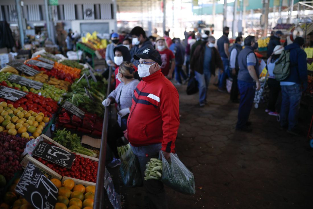 Personas con tapabocas hacen compras en el Mercado Central de Frutas y Verduras de la provincia de Buenos Aires, Argentina.