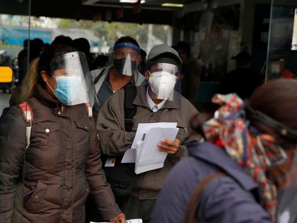 FOTO DE ARCHIVO. Personas con mascarillas y protectores faciales hacen fila antes de abordar autobuses, durante el brote de la enfermedad por coronavirus (COVID-19), en Lima, Perú. 15 de julio de 2020. REUTERS/Sebastián Castañeda