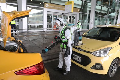 Un trabajador desinfecta los taxis que llegan al Aeropuerto Internacional El Dorado, en Bogotá (Colombia). EFE/Carlos Ortega