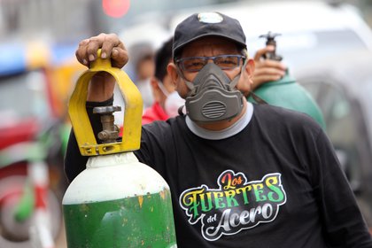 Un hombre con una máscara facial hace cola junto a su botella de oxígeno, que quiere rellenar, en medio de la pandemia de coronavirus (DPA) 