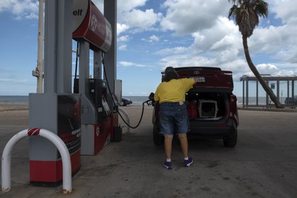 Una cliente carga combustible como parte de los preparativos para el huracán (AFP)