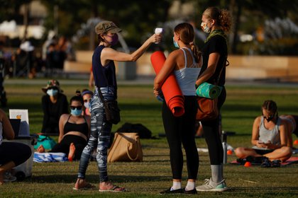 A la gente se le controla la temperatura al llegar a una clase de yoga al aire libre en un parque del centro de la ciudad durante el brote del coronavirus (COVID-19) en San Diego, California, el 24 de agosto de 2020. REUTERS/Mike Blake