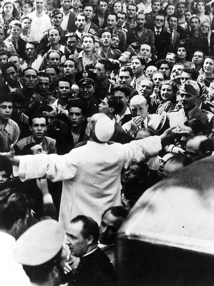 Hombres, mujeres y soldados reunidos alrededor del Papa Pío XII el 15 de octubre de 1943, durante una gira papal por Roma después de un bombardeo. (AP Photo/archivo) 