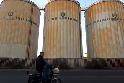 Una persona pasa frente a silos usados para guardar grano en China. Foto: REUTERS/Yilei Sun