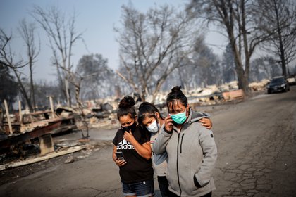 Sandra, Daniela y Ester Reyes son vistas después de que los incendios destruyeran un vecindario en Bear Creek, Phoenix, Oregon, el 10 de septiembre de 2020 REUTERS/Carlos Barria