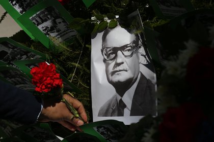 Un hombre deja una flor sobre la imagen del presidente chileno Salvador Allende, este viernes en Santiago. EFE/Elvis Gonz&#225;lez 