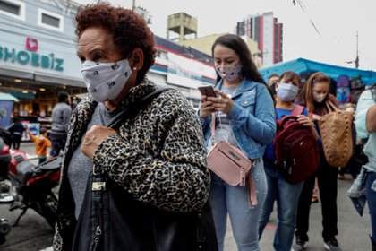 Personas con tapabocas hacen fila hoy en un sector comercial de Sao Paulo (Brasil). EFE/Sebastiao Moreira/Archivo 
