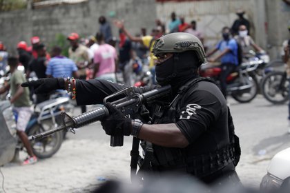 Un oficial de la Policía Nacional Haitiana (PNH) de guardia pide a los manifestantes que se alejen durante una protesta organizada por el grupo Fantom 509 en las calles de Puerto Príncipe, Haití, el 14 de septiembre de 2020 (REUTERS/Andrés Martínez Casares)
