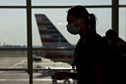Una viajero con máscara facial en el Aeropuerto Nacional Ronald Reagan en Arlington, Virginia (Bloomberg)