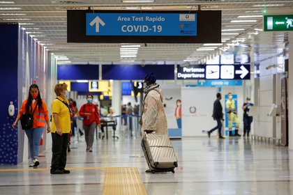 Pasajeros a lo largo de un corredor del aeropuerto, después de que Italia hiciera que las pruebas para detectar coronavirus fueran obligatorias para los viajeros de partes de Francia que tienen un gran número de casos, en el aeropuerto de Fiumicino en Roma (Reuters)