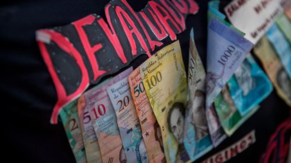 Fotografía de varios billetes del cono monetario venezolano pegados en un cartel de protesta en Caracas (Venezuela). Foto: EFE/ Miguel Gutiérrez 