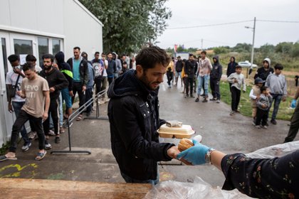 Un migrante recibe comida cerca de la frontera entre Serbia y Hungría. REUTERS/Marko Djurica