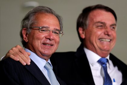 El Ministro de Economía de Brasil, Paulo Guedes, sonríe junto al Presidente Jair Bolsonaro, antes de la ceremonia de lanzamiento del programa Voo Simples en Brasilia, el 7 de octubre de 2020 (REUTERS/Ueslei Marcelino)