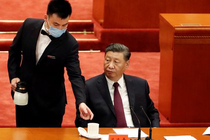 El jefe de estado chino, Xi Jinping, es atendido por un asistente durante una cumbre en el Gra Hall del Pueblo de China, en Beijing (Reuters)