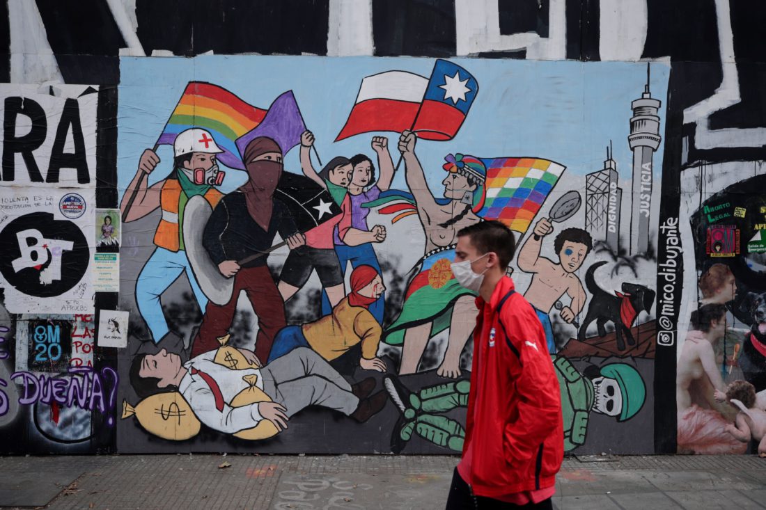 Un hombre camina frente a un graffitti en Santiago de Chile. EFE/Alberto Valdés/Archivo
