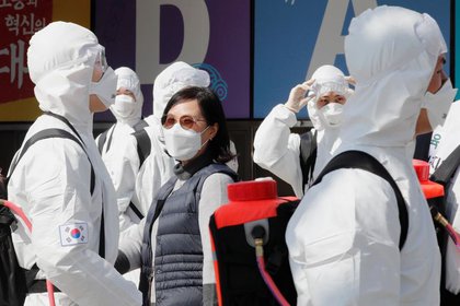 Soldados surcoreanos con trajes y mascarillas protectoras sanitizan Daegu, Corea del Sur. REUTERS/Kim Kyung-Hoon