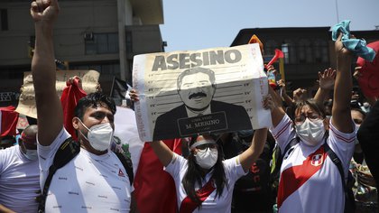 Manifestantes pidiendo la renuncia del presidente interino, Manuel Merino, con un cartel que dice "Asesino", poco antes de que Merino anunciara su renuncia en Lima, Perú, el domingo 15 de noviembre de 2020. (AP Foto/Rodrigo Abd)