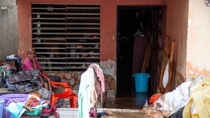 Un hombre permanece sentado fuera de su casa junto a sus enceres dañados y mojados por las fuertes lluvias (EFE/ Henry Chirinos) 