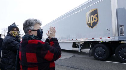 Vecinos de Michigan aplauden la salida de los camiones cargados de vacunas de la planta de Pfizer 