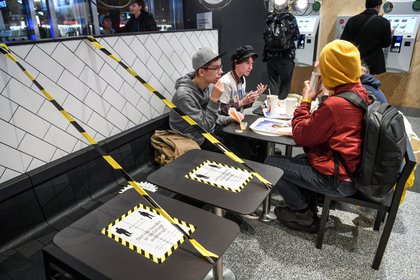 Jóvenes comen en un ambiente cerrado de un restaurante en la capital sueca (Reuters)