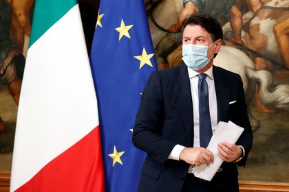 El primer ministro italiano Giuseppe Conte, con una máscara facial protectora, se retira al final de la conferencia de prensa de este viernes sobre las nuevas medidas contra el COVID-19 (REUTERS/Remo Casilli)