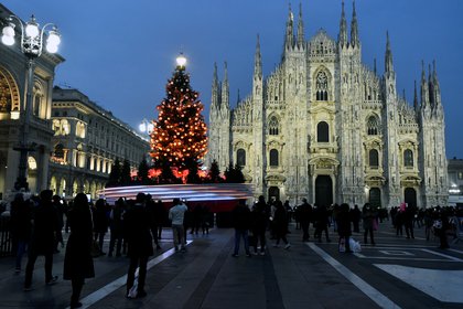 La gente toma fotos del árbol de Navidad en la plaza del Duomo en Milán el 18 de diciembre de 2020. REUTERS/Flavio Lo Scalzo