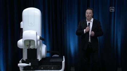 Elon Musk junto al robot que se utilizaría en las cirugías para insertar los chips en el cerebro