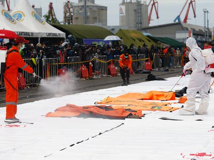 Personal de la Cruz Roja aplica desinfectante en bolsas para cadáveres, a la espera del traslado de los restos (Reuters)