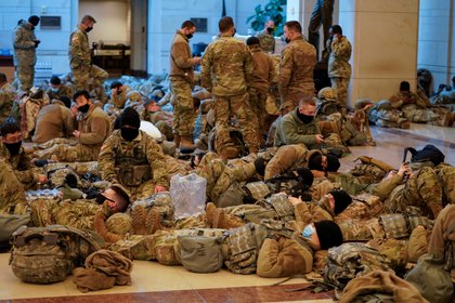 Miembros de la Guardia Nacional descansan en el Capitolio la noche anterior del debate por el Juicio Político al presidente Donald Trump (REUTERS/Joshua Roberts)