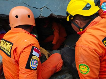 Miembros del equipo de rescate buscan sobrevivientes entre los escombros luego del terremoto de Indonesia