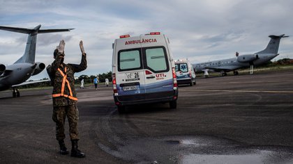 Ambulancias llevan a enfermos de COVID-19 hacia aviones para que sean trasladados y atendidos en otras ciudades (EFE/Raphael Alves)