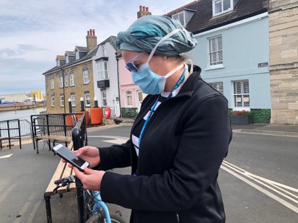 Una trabajadora del Servicio Nacional de Salud observa la aplicación del NHS para rastrear contactos de personas potencialmente infectadas en la Isla de Wight, el 5 de mayo de 2020 (REUTERS/Isla Binnie)