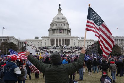 Un seguidor de Donald Trump sostiene la bandera de los Estados Unidos, el 6 enero de 2021, frente al Capitolio estadounidense, en Washington (Estados Unidos). EFE/MICHAEL REYNOLDS 